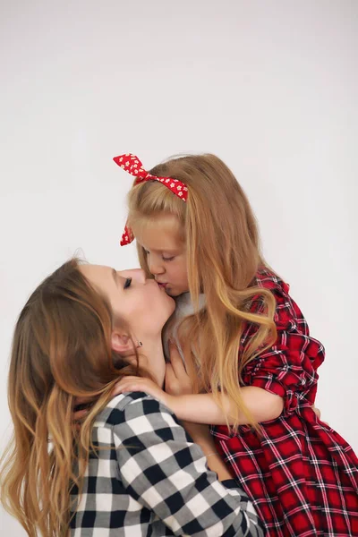 Happy loving family. Mother and her daughter girl kissing and hugging in the room. Woman and girl with curlers on her head. — Stock Photo, Image