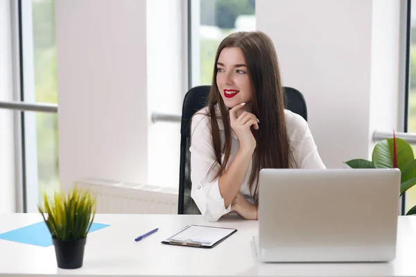 Młoda kobieta siedząca przy stole z laptopem w białym biurze. student lub businesswoman — Zdjęcie stockowe