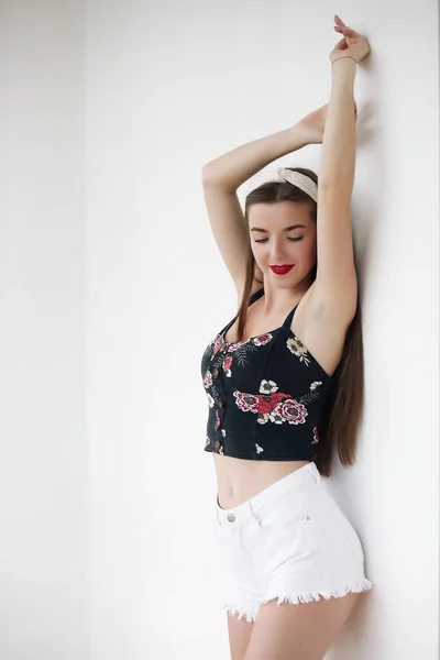 Menina feliz em shorts de ganga vintage em pé em pose confiante no fundo amarelo. — Fotografia de Stock