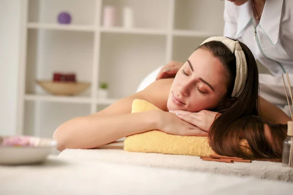 Attraente ragazza godendo di un massaggio facciale in una spa — Foto Stock