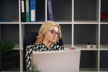 Güzel bir iş kadını ofisinde bilgisayarla çalışırken hayal kuruyor.