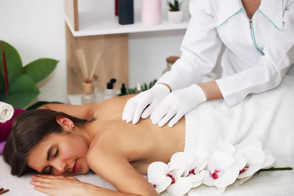 Rug massage.Young mooie europese vrouw slapen ontspannen op olie spa massage in salon. — Stockfoto