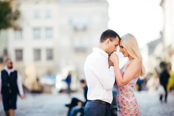 Jeune couple amoureux s'embrasser sur fond de ville — Photo