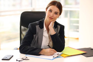 İş yerindeki iş kadını. Şirket yöneticisi. Ofisteki belgelere bakan bir kadın. Profesyonel kurumsal kıyafet kodu