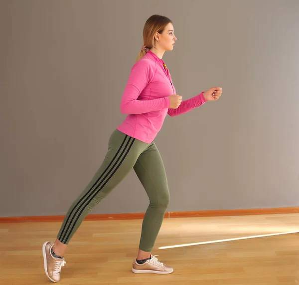 Vrouw in modieuze sportkleding. Dynamische beweging. Zijaanzicht. Sport en een gezonde levensstijl — Stockfoto