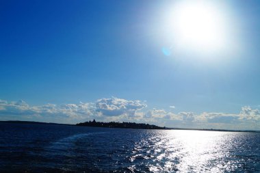 Güneş ışınları gölün mavi suyuna yansır.