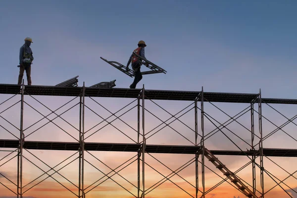 Mann arbeitet auf Baustelle mit Baugerüst und baut mit — Stockfoto