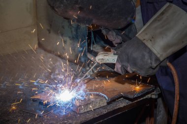 Bir adam yetenekli fabrika kaynakçı, kesme, taşlama, matkap