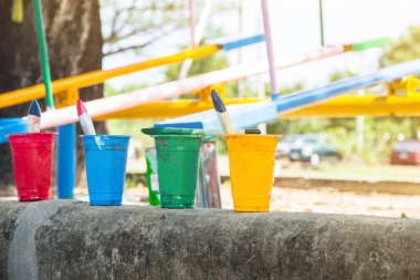 Tasarım için bardak boya arka planda dinlenmiş boya fırçası, kullanılmış işler