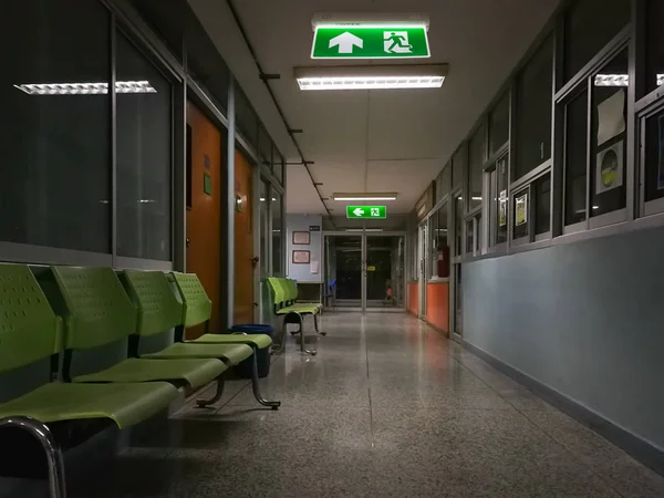 Green emergency exit sign in hospital showing the way to escape — Stock Photo, Image