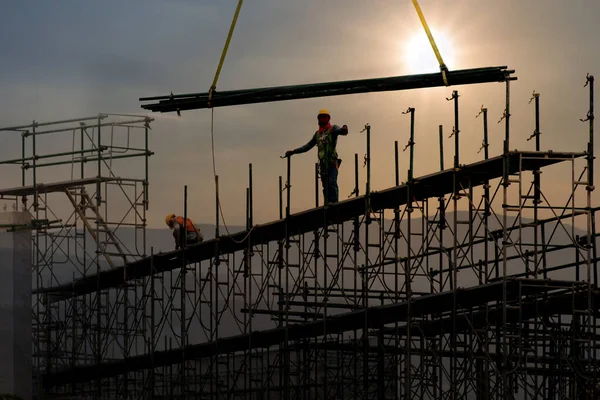 Hombre trabajando en el sitio de construcción con andamio y la construcción con —  Fotos de Stock