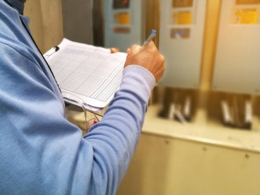 Elektrik veya Enstrüman teknisyeni ağır sanayi tesisi, bakım ve servis consepsindeki elektrik kontrol dolabını kontrol ediyor