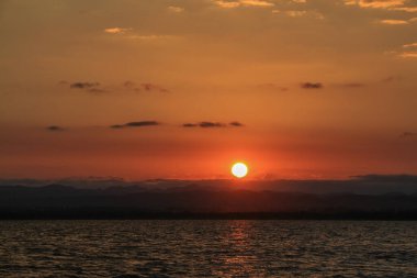 Bulutlu, natur ile göl üzerinde mavi gökyüzü ile gün doğumu manzarası