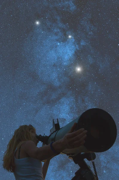 Woman looking in telescope on space background