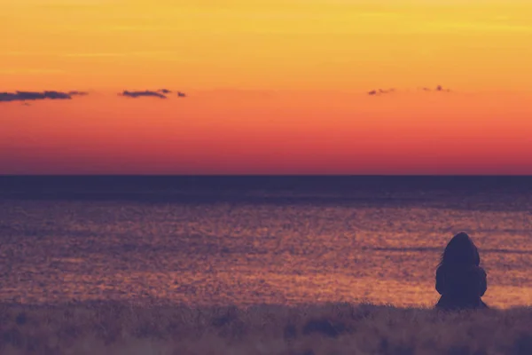 Loneliness concept. Woman sitting with back and looking forward