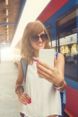 Selfie Tren İstasyonu yakınında dururken smartphone alarak kadın 