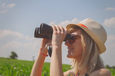 Mısır alanında dürbün ile arayan kadın 