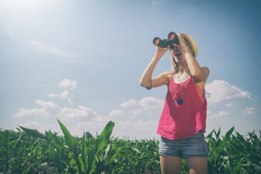 Mısır alanında dürbün ile arayan kadın 