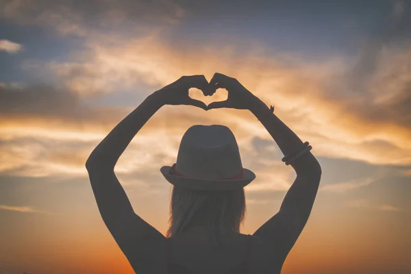 Back View Woman Hat Raised Hands Showing Heart Sign Sunset — Stock Photo, Image