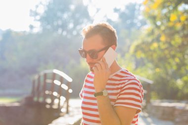 Genç adam akıllı telefon kullanıyor.