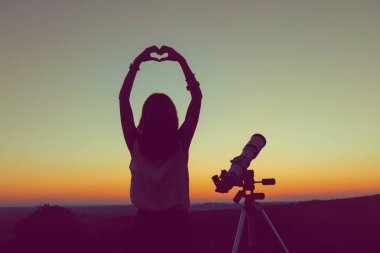 Geceleri bir teleskop kullanan kız