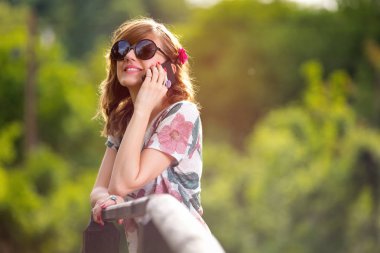 Kadın akıllı Park ahşap köprü üzerinde dururken söz
