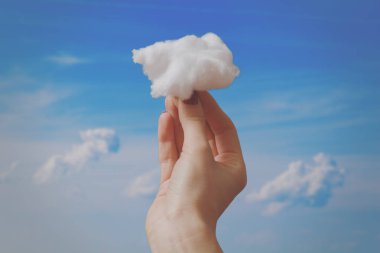 Bir bulut mavi gökyüzü arka plan üzerinde tutan eller