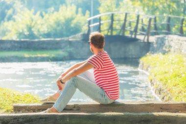 Bir oturum parkta oturan genç adam