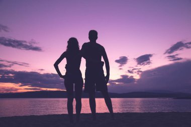 Çift sahilde günbatımı içinde zevk / gündoğumu kez