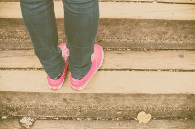 Kadın yürürken, pembe spor ayakkabı ayaklarda görünümü kapatın