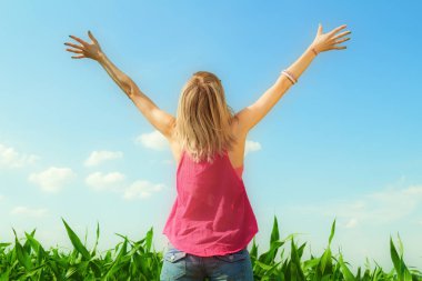 arkadan ellerini gökyüzüne Mısır alanında yetiştirme ile kadın görünüşü 