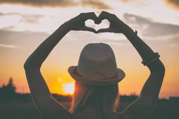 Back View Woman Hat Raised Hands Showing Heart Sign Sunset — Stock Photo, Image