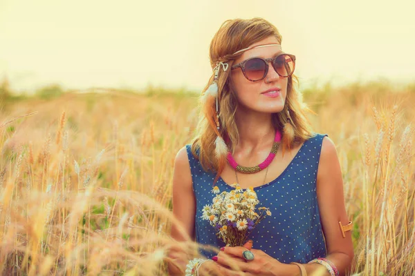 美丽的妇女在太阳镜持有野花花束 而放松在大麦草甸 — 图库照片