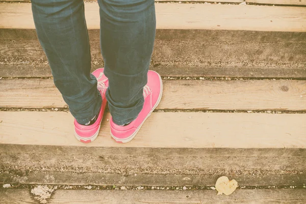 Kadın yürürken, pembe spor ayakkabı ayaklarda görünümü kapatın