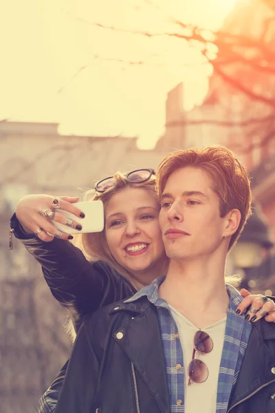 年轻夫妇在爱采取自拍智能手机在街上 — 图库照片