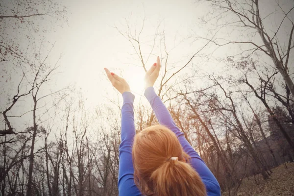 kadının kuyruk saç modeli saç modeli ile arkadan görünüm sonbahar orman havada ellerini kaldırdı 