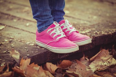 kadın pembe ayakkabı sonbahar düşen yapraklar ile ahşap platformda ayakta bacaklarda 