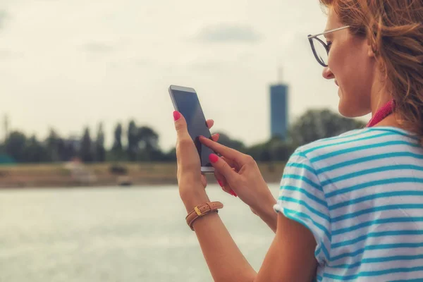 Mujer Usando Teléfono Inteligente Terraplén Con Paisaje Urbano Fondo — Foto de Stock