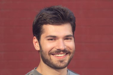 kırmızı tuğla duvar arka plan üzerinde poz mutlu gülümseyen adam portresi 