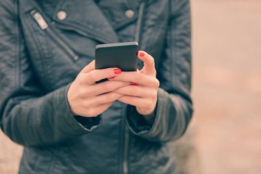 Kırmızı manikür smartphone açık, yakın çekim kullanarak ile eller 