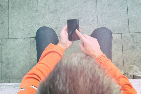 Smartphone açık, en iyi görünümü'yazarak giyen turuncu kazak dostum 