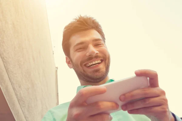Feliz Hombre Sonriente Mirando Cámara Mientras Usa Teléfono Inteligente Calle —  Fotos de Stock
