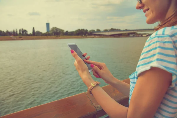 Mujer Usando Teléfono Inteligente Terraplén Con Paisaje Urbano Fondo — Foto de Stock