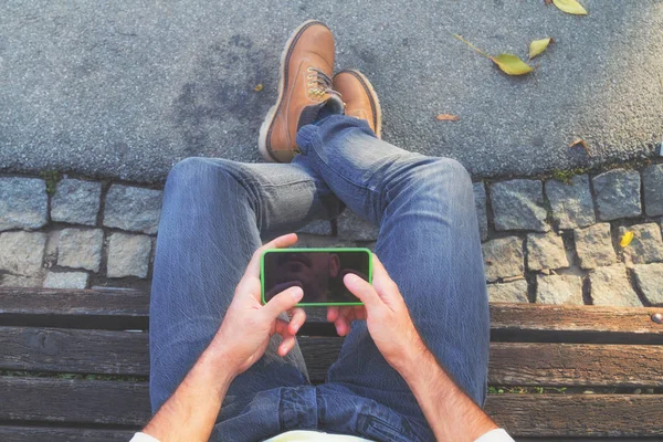 tahta bankta oturan ve smartphone açık, en iyi görünümü'nü kullanarak adam 