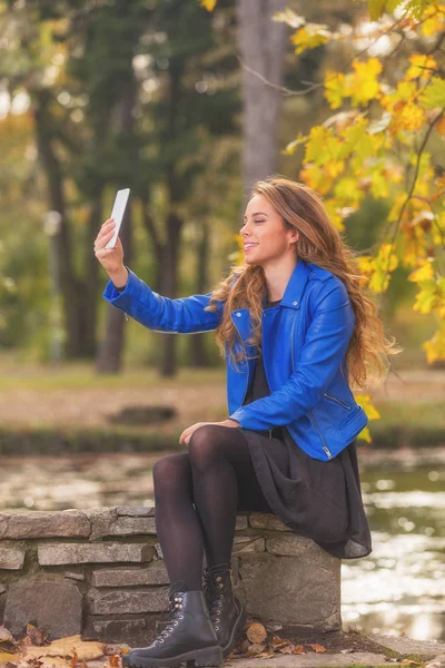 Mosolygó Gyönyörű Vesz Selfie Smartphone Kerítés Őszi Parkban Ülve — Stock Fotó