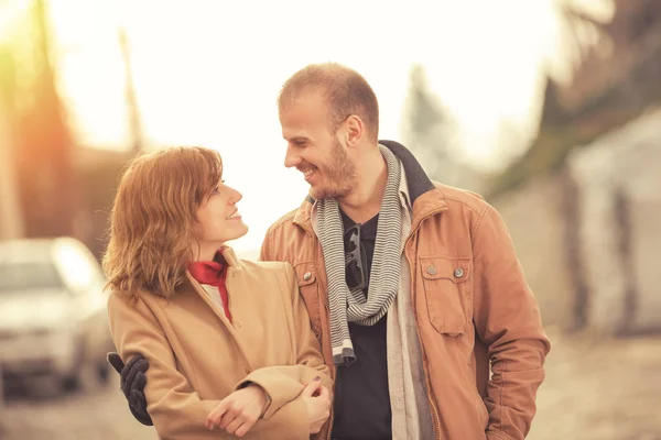 sweet couple smiling and hugging while standing on blurred street