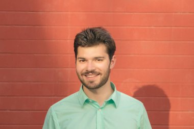 kırmızı tuğla duvar arka plan üzerinde poz mutlu gülümseyen adam portresi 