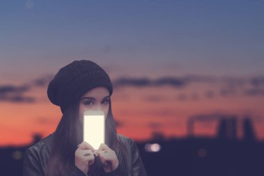 Kentsel kız cep telefonu açık havada tutan.