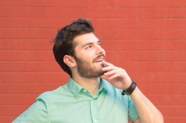 portre dalgın adam kırmızı tuğla duvar arka plan üzerinde poz 