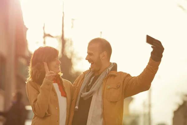 Mann Macht Selfie Mit Smartphone Und Frau Zeigt Friedenszeichen Auf — Stockfoto